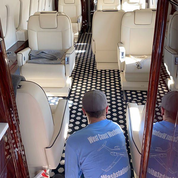 man cleaning airplane interior
