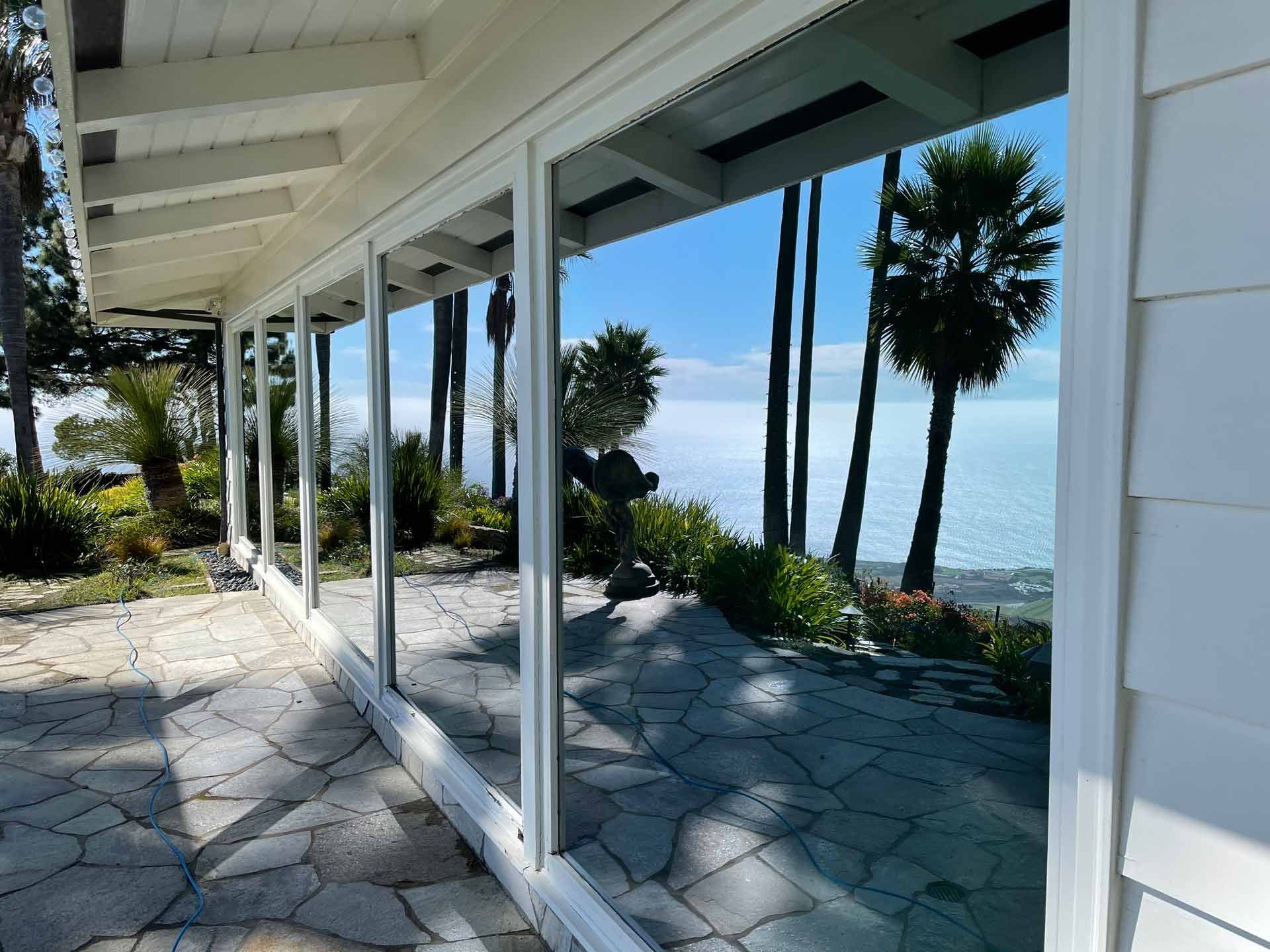 a house with a view of the ocean and palm trees