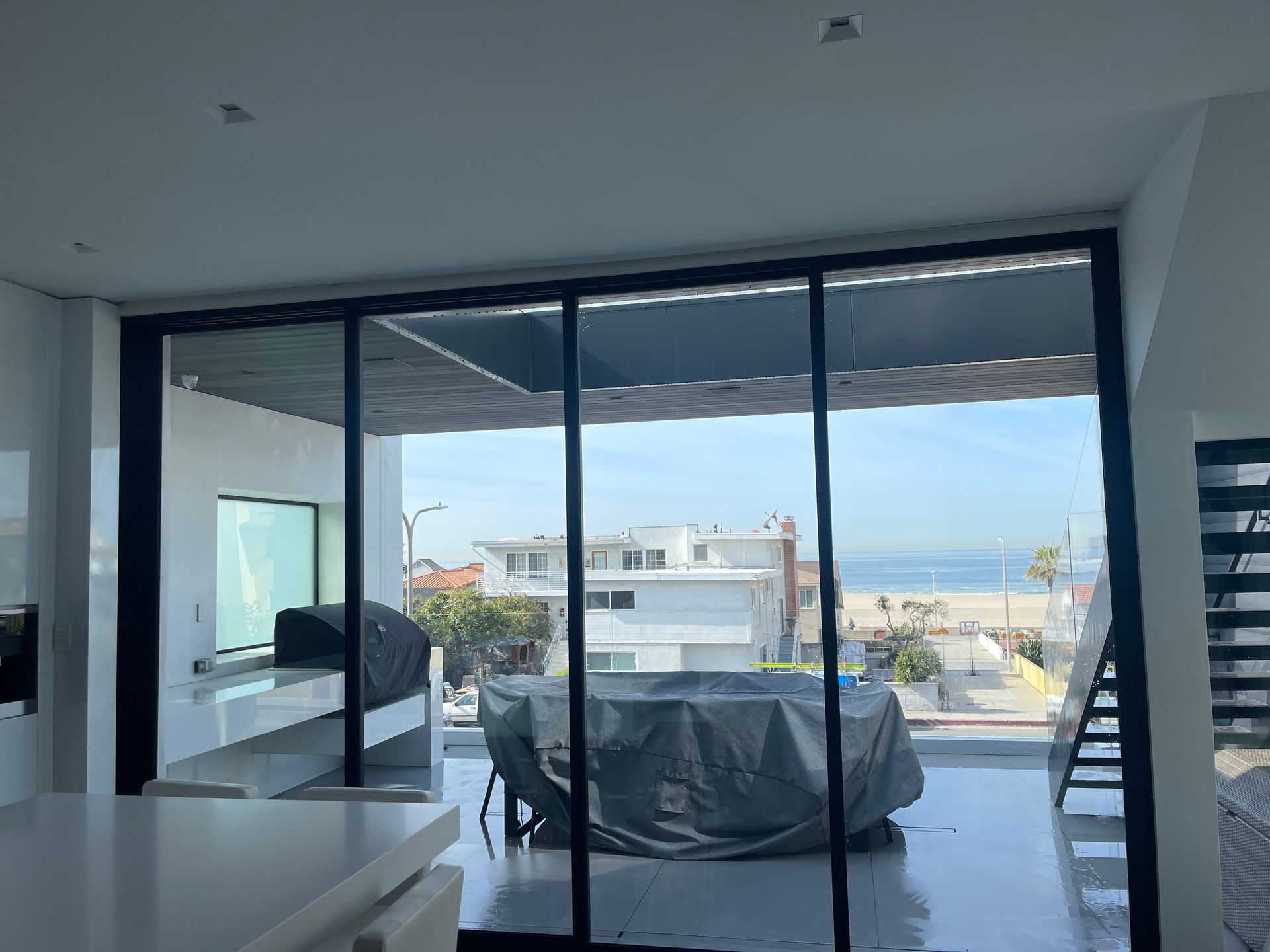a living room with sliding glass doors leading to a balcony overlooking the ocean