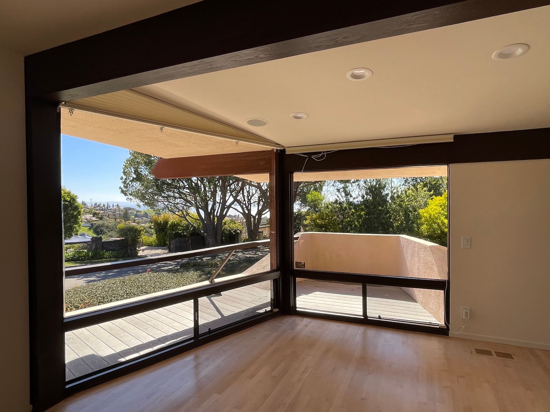 an empty room with a lot of windows and a balcony