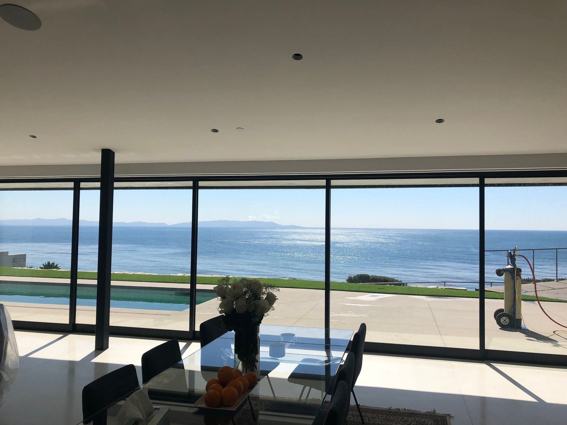 a dining room with a table and chairs and a view of the ocean
