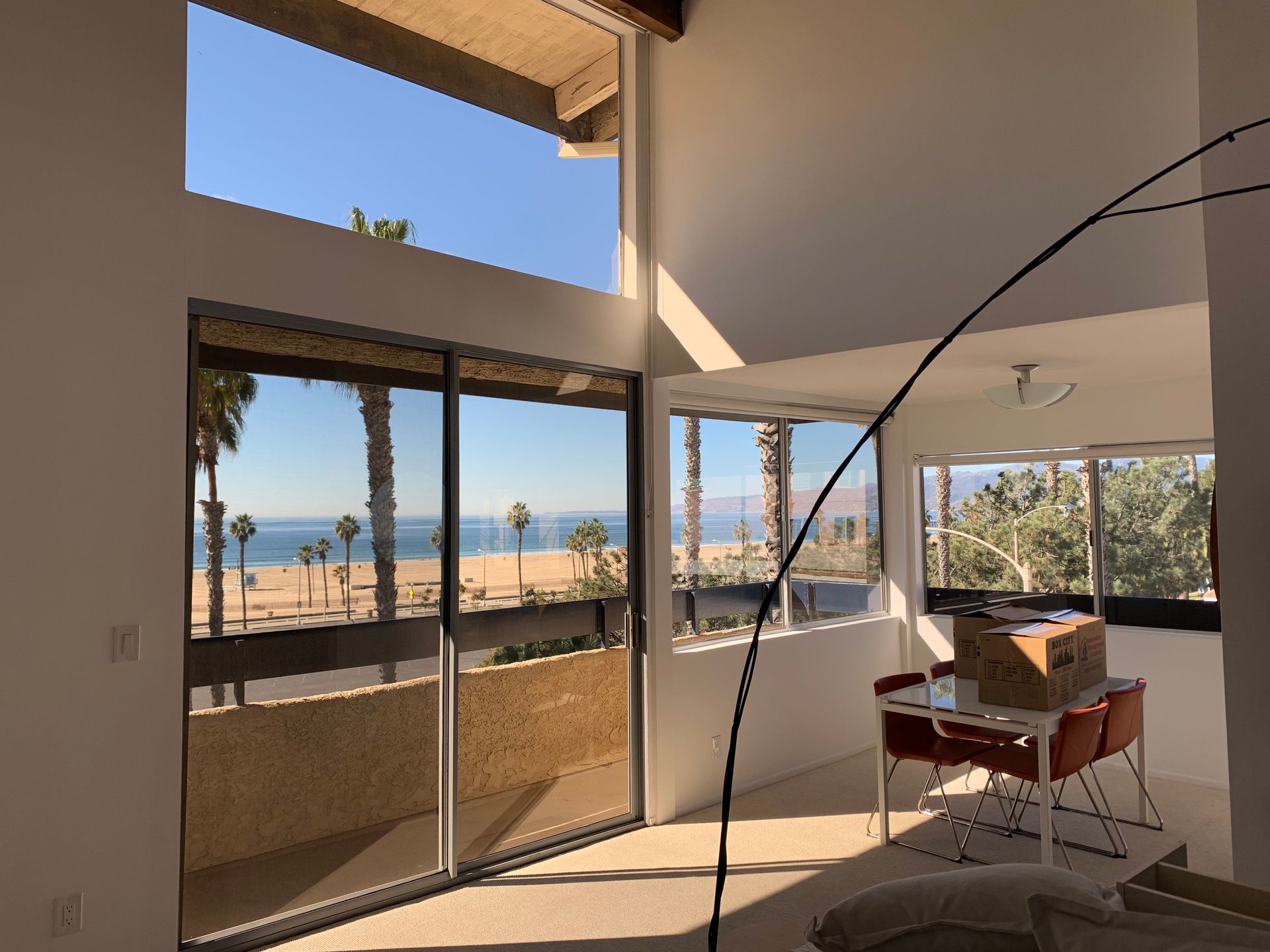 a living room with a table and chairs and a view of the ocean