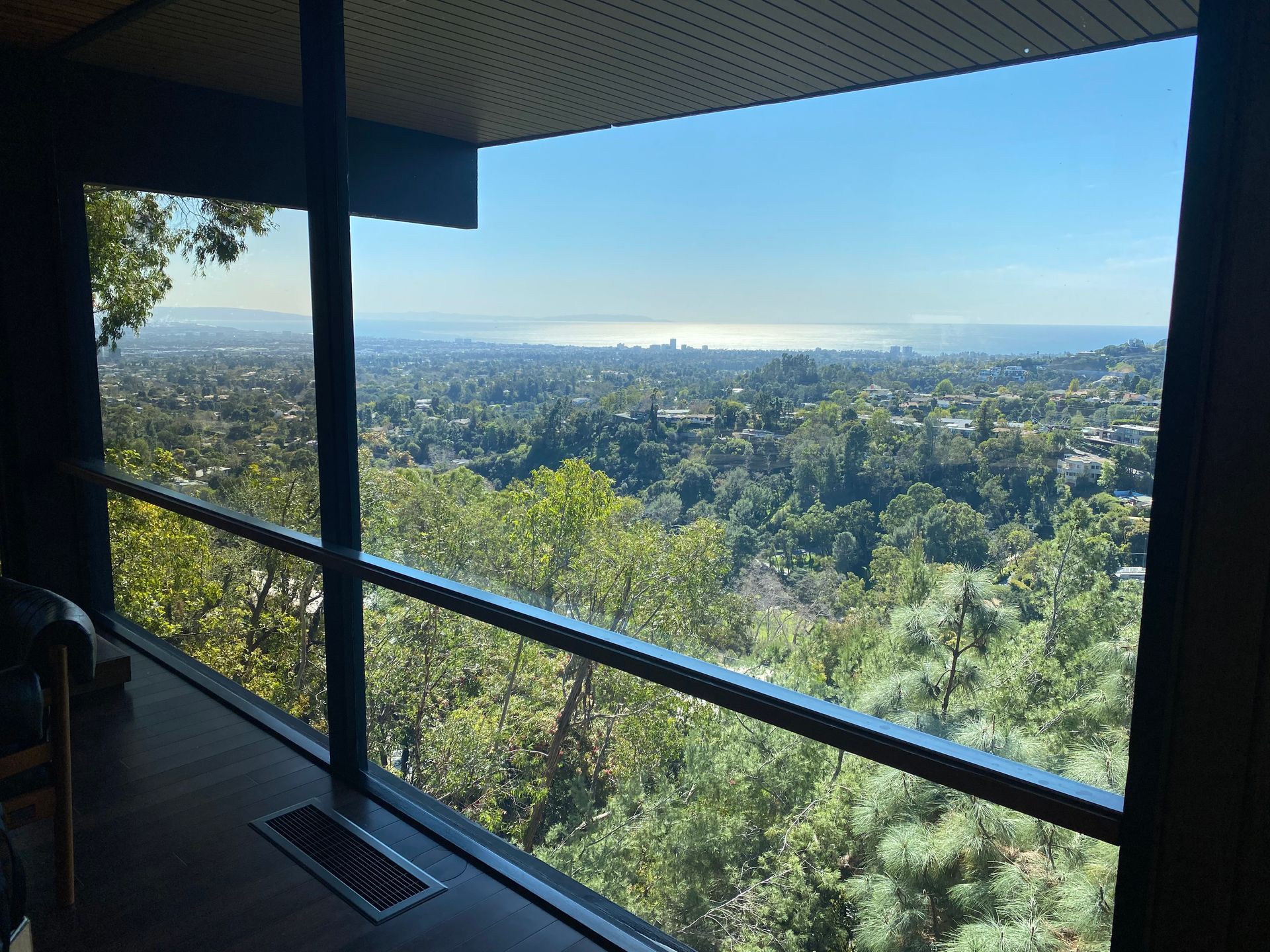 a large window with a view of a city and trees