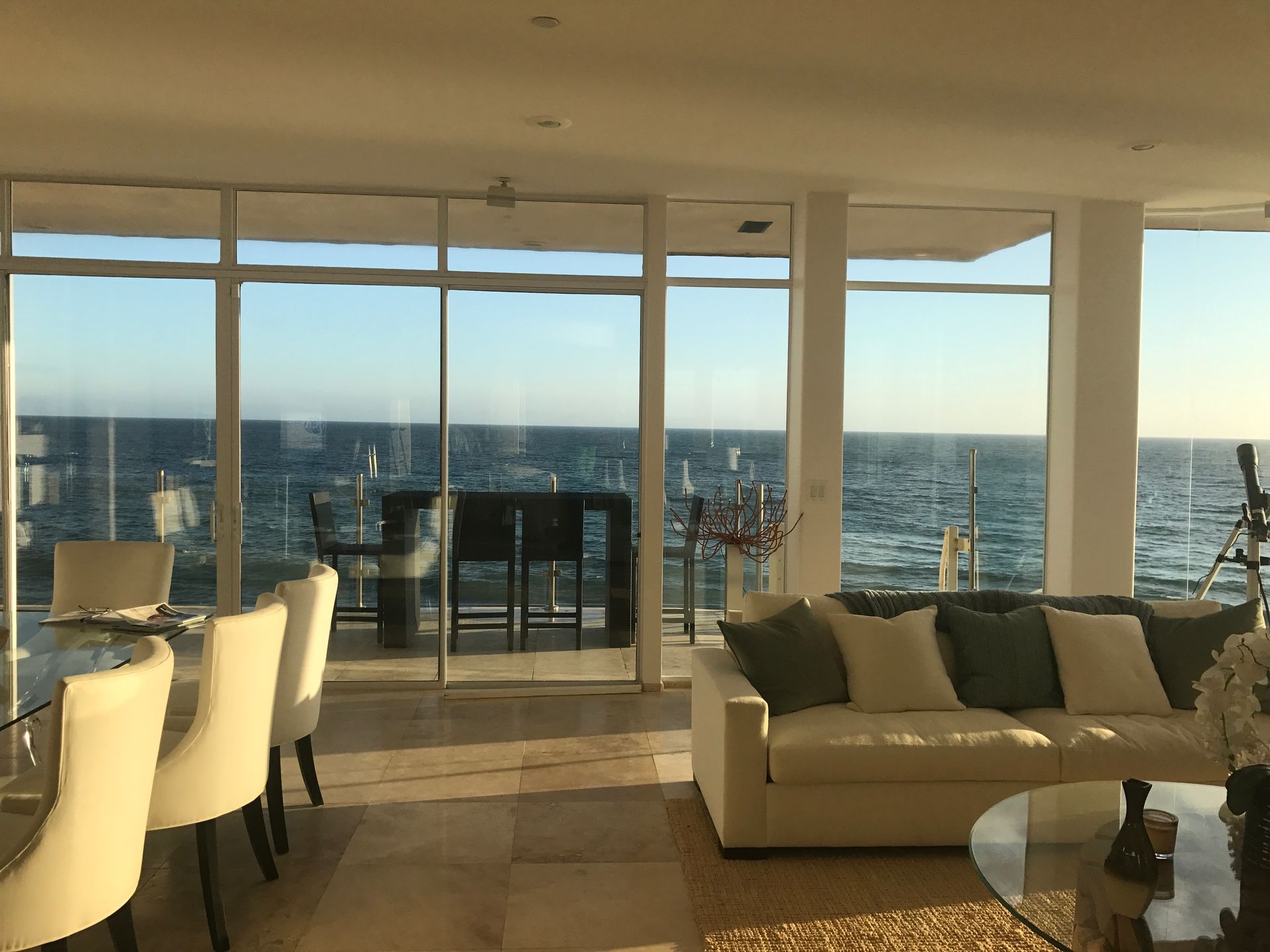 a living room with a couch and chairs and a view of the ocean