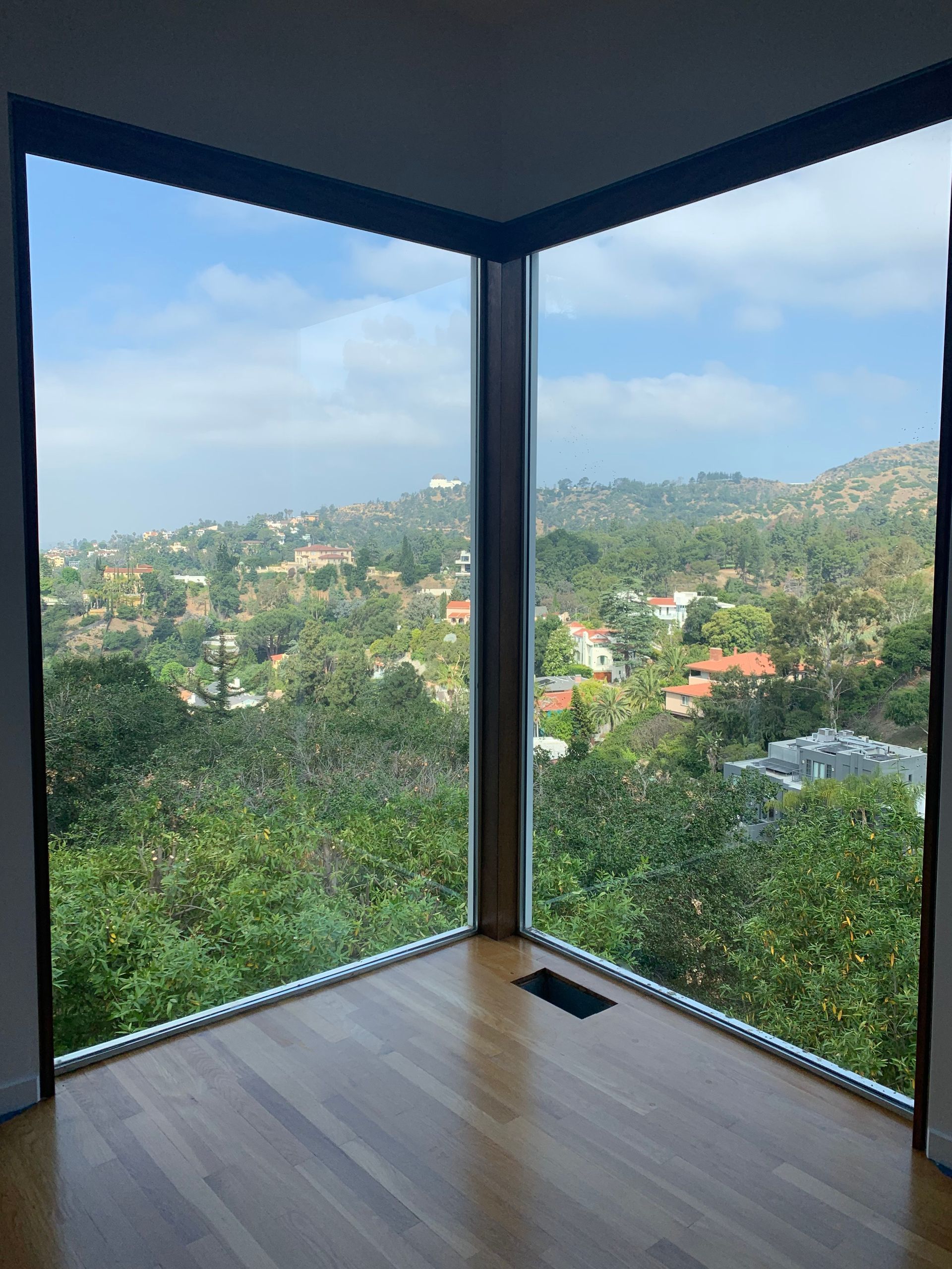 an empty room with a view of a forest from a large window .