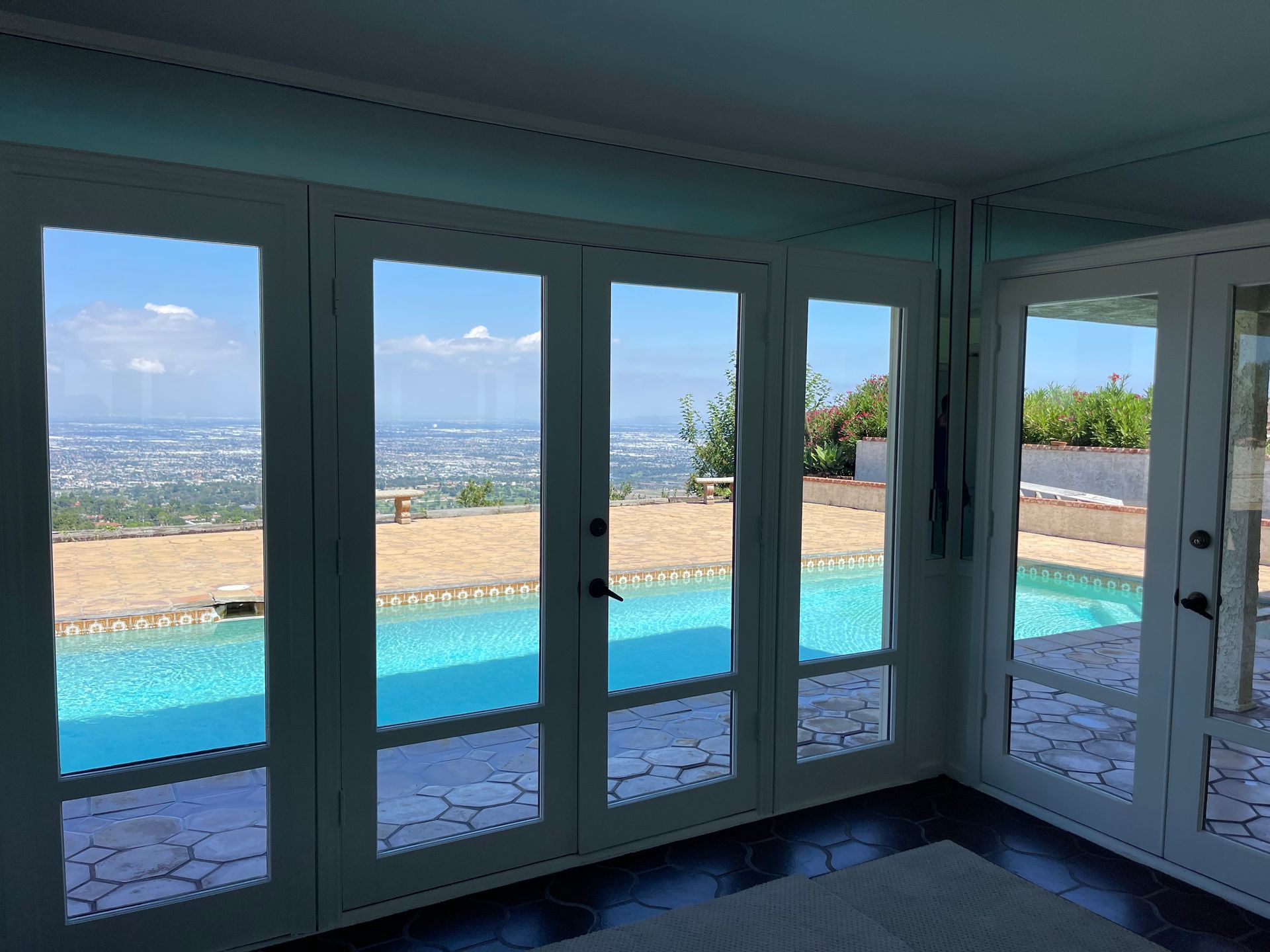a room with a view of a swimming pool and a city