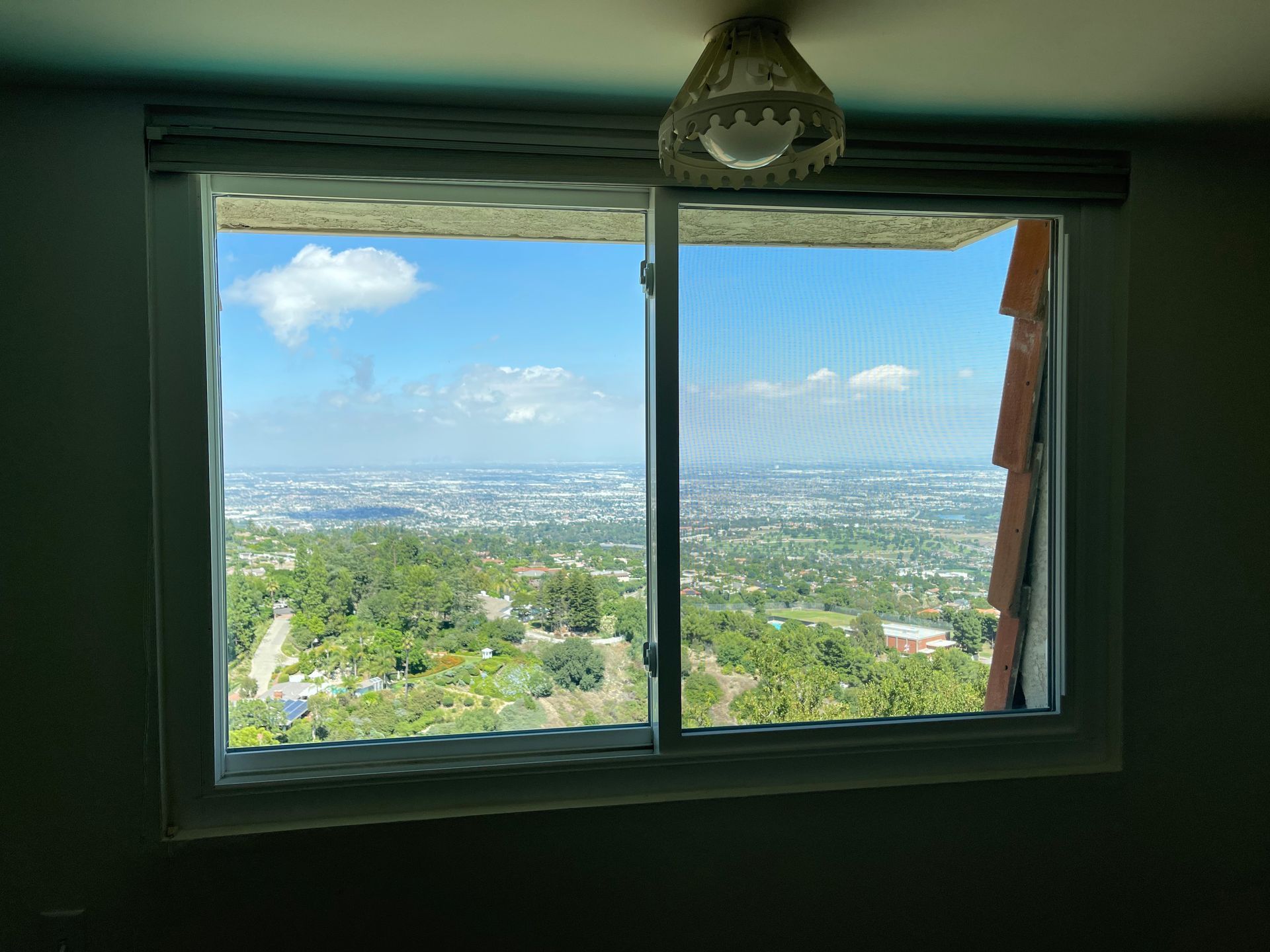 a window with a view of a city and trees