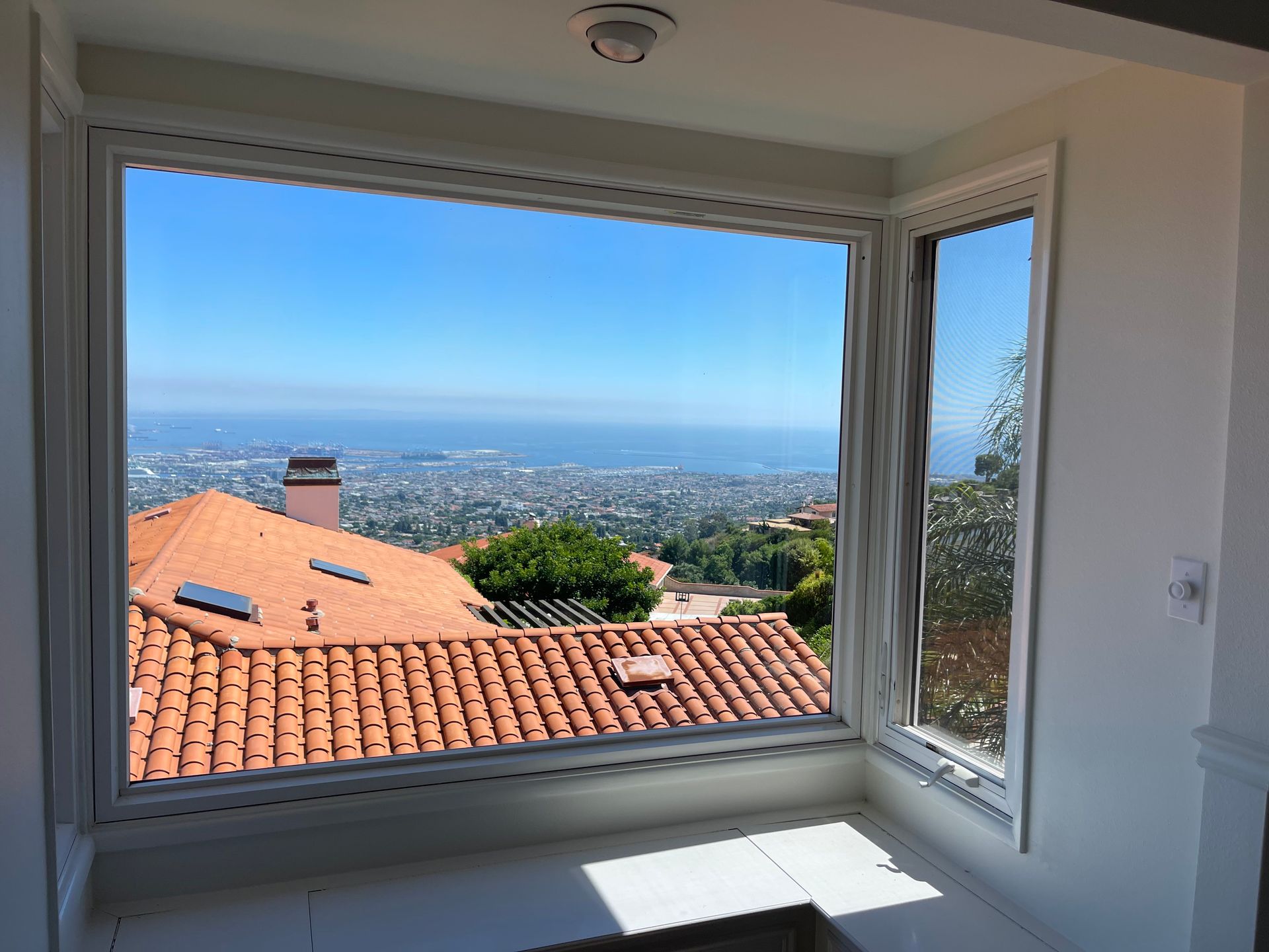 a large window with a view of a city and a roof