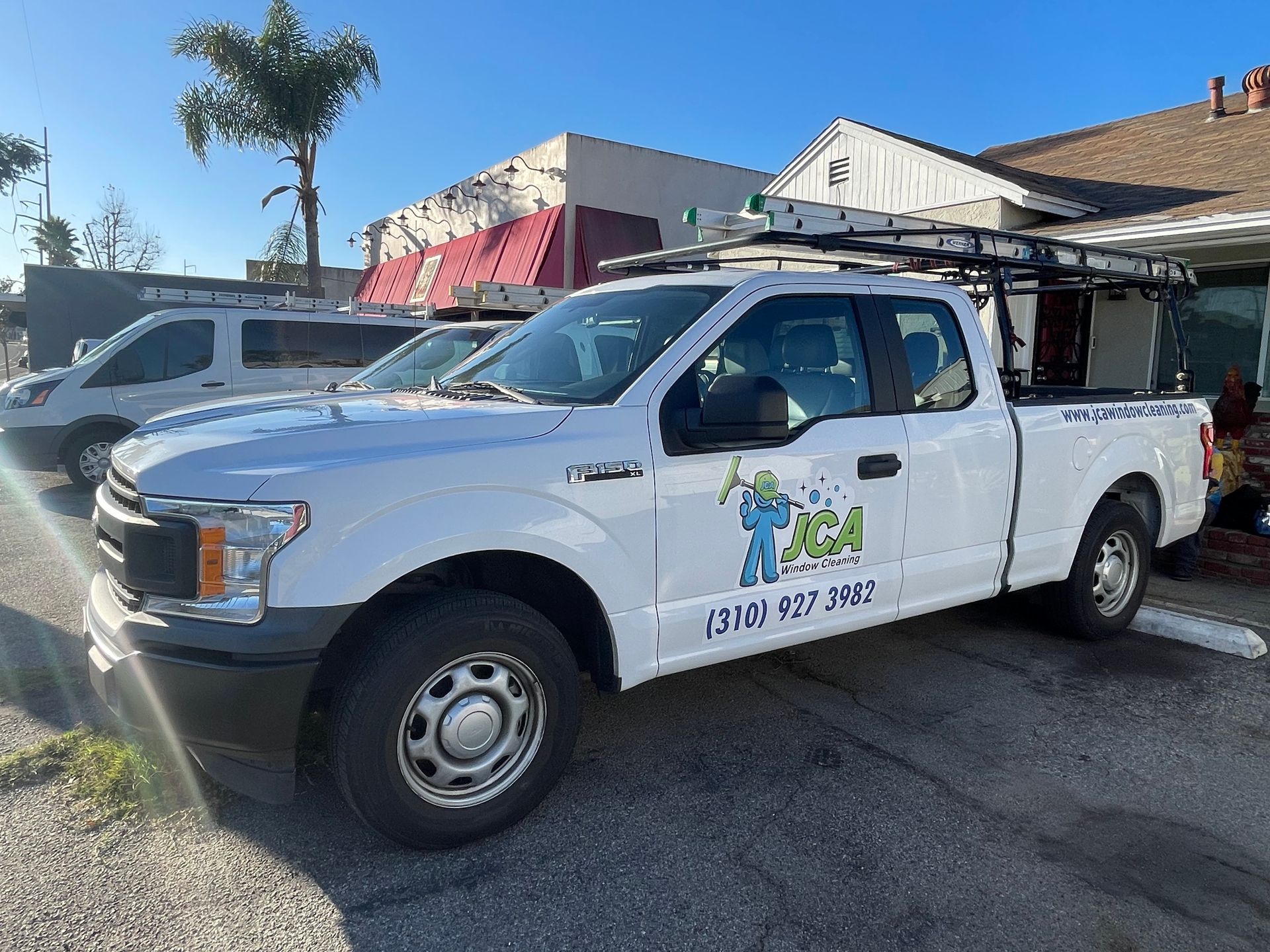 jca window cleaning truck is parked in front of a house