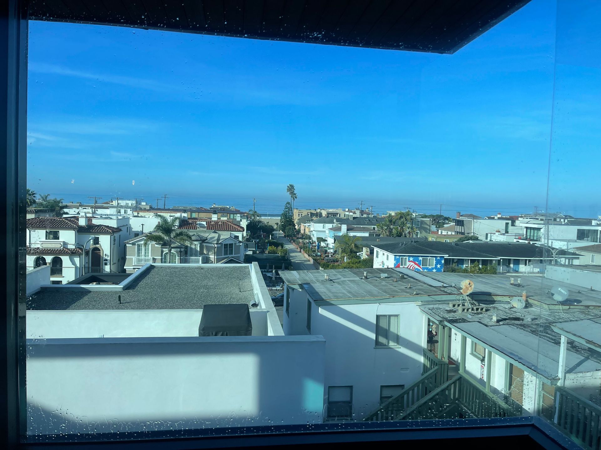 a view of a city from a window with a blue sky