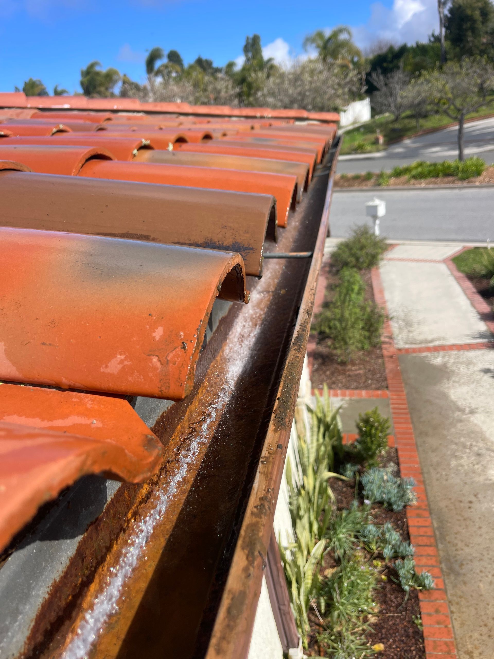 a close up of a rusty and dirty gutter on a roof