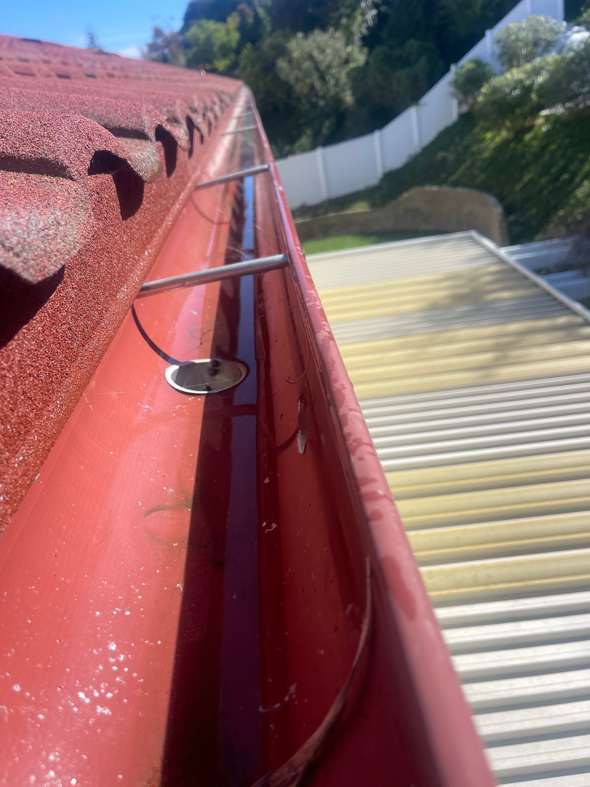 a red gutter is attached to the roof of a building