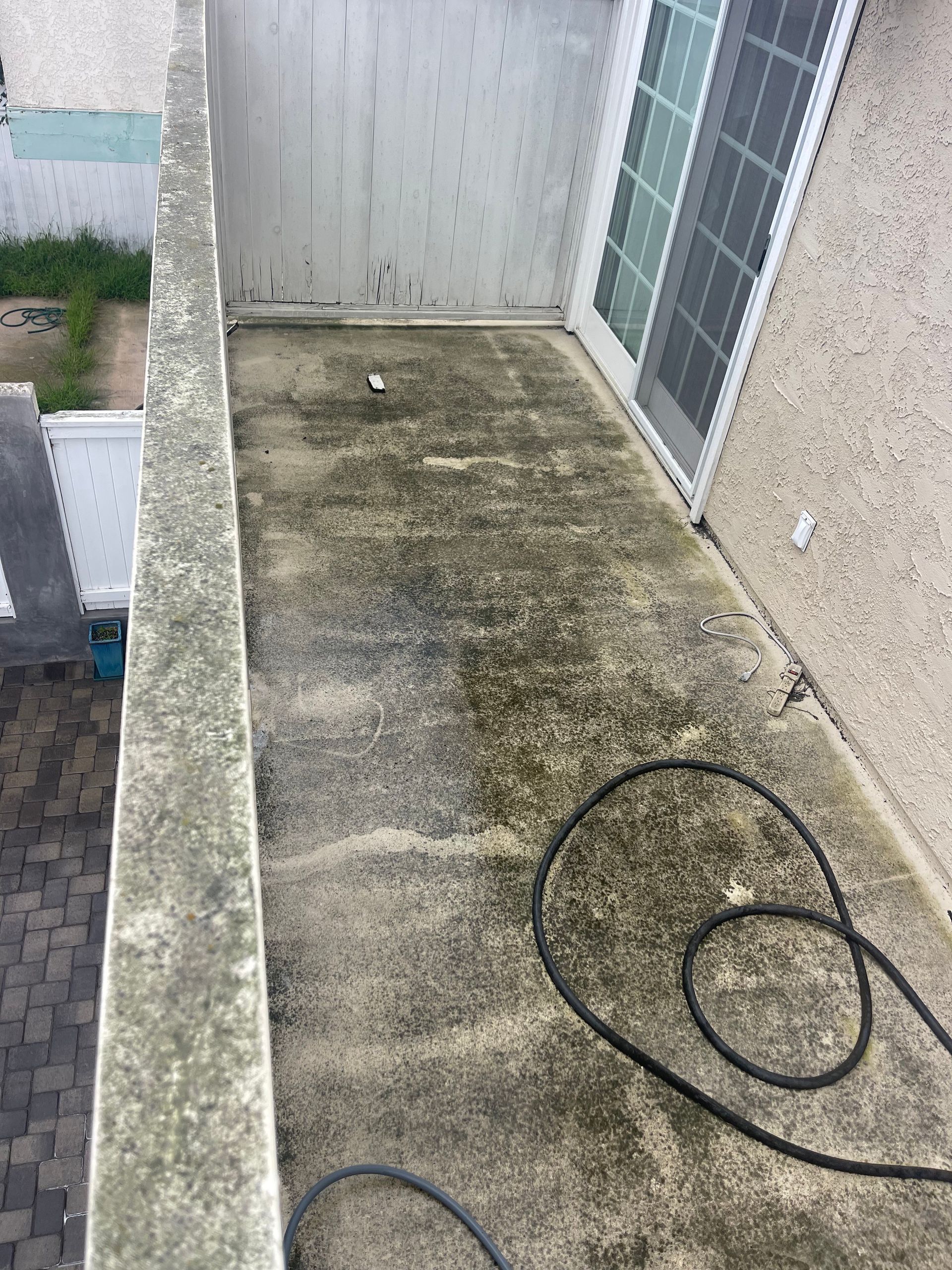 a dirty concrete balcony with a hose attached to it