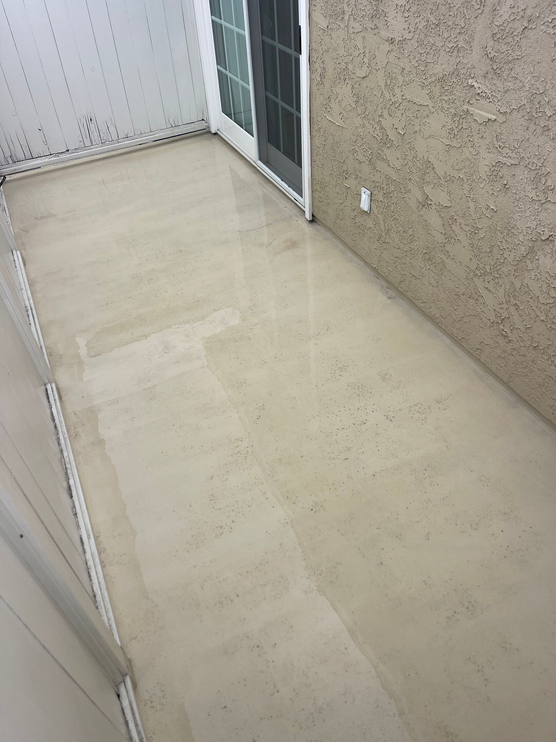 a room with a concrete floor and a sliding glass door