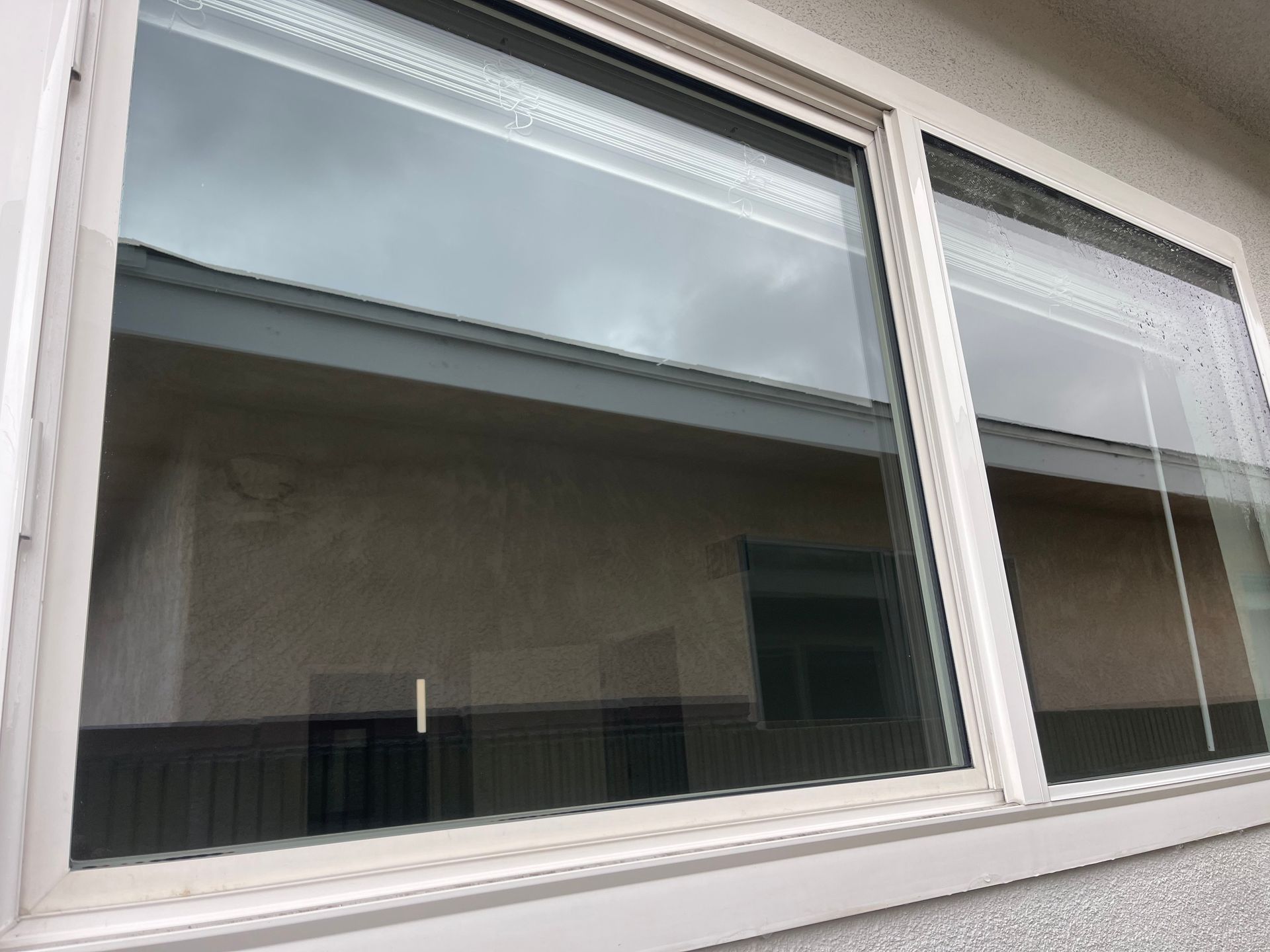 a large window on the side of a building with a reflection of a building in the window