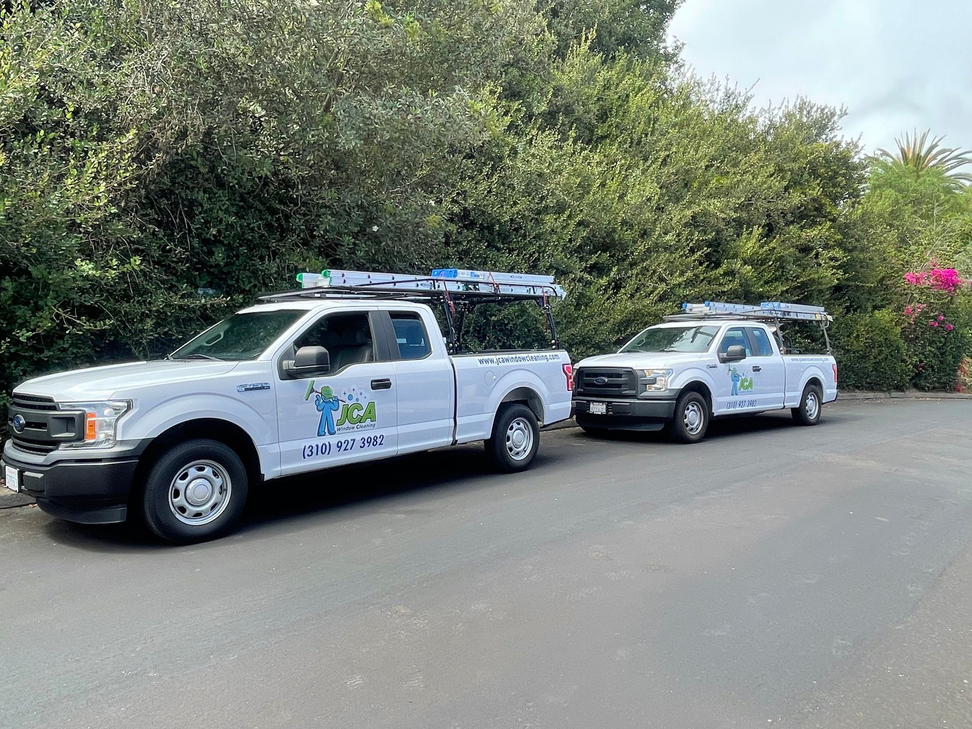 two white trucks are parked next to each other in a parking lot