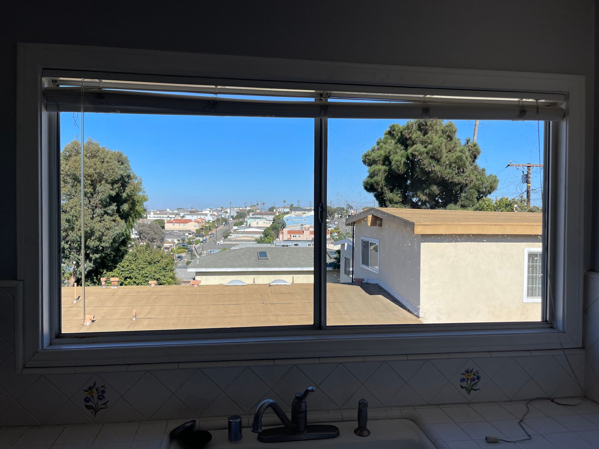 a kitchen sink with a view of a house through a window