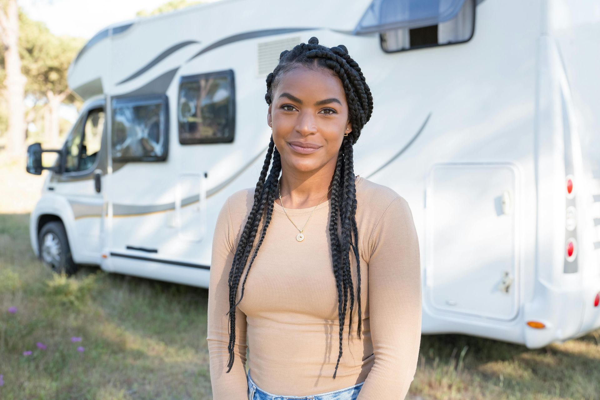 A woman is standing in front of a camper van.