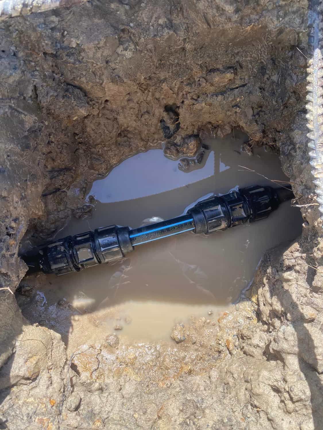 Broken Pipe Leaking Water into Dirt, Forming Puddle — Old Mate Plumbing Co in Hollywell, QLD