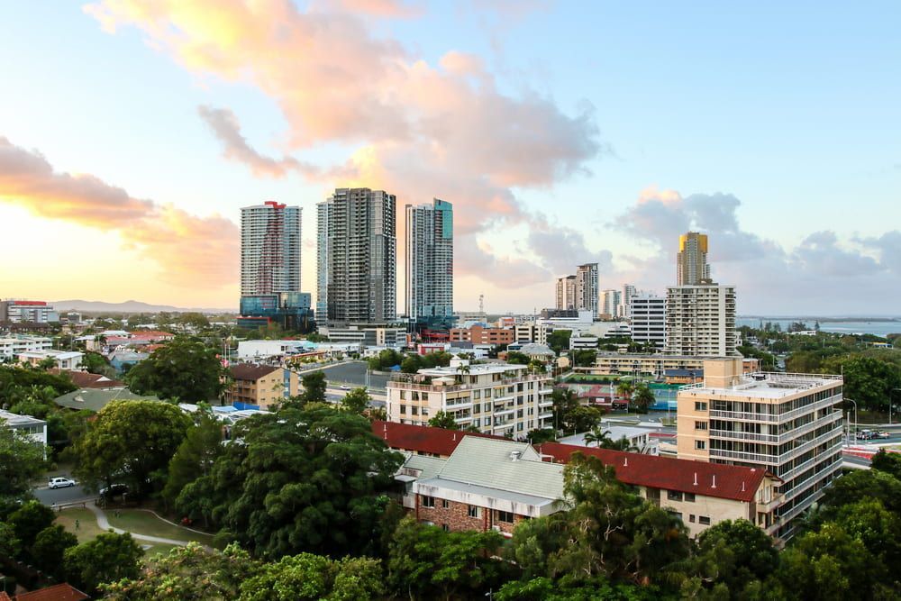 An Aerial View Of A City With Lots Of Buildings And Trees At Sunset — Old Mate Plumbing Co in Southport, QLD