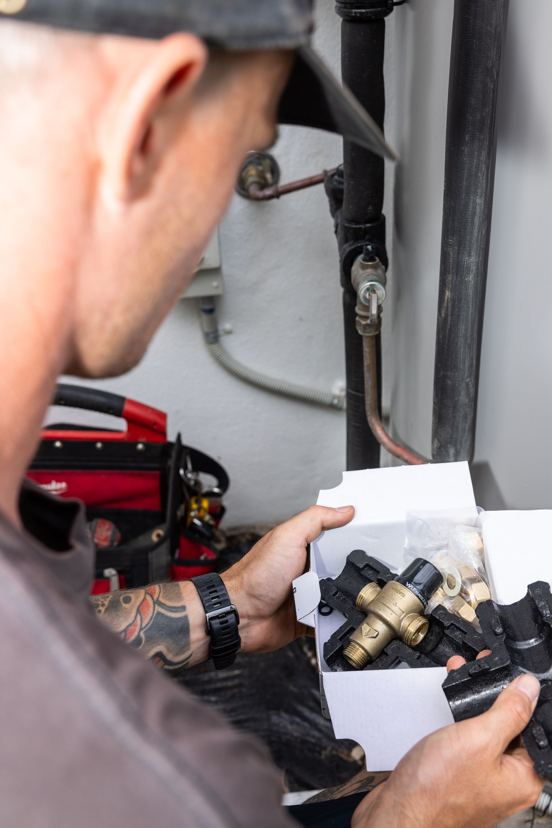 A Man is Instaling New Pipes— Old Mate Plumbing Co in Hollywell, QLD