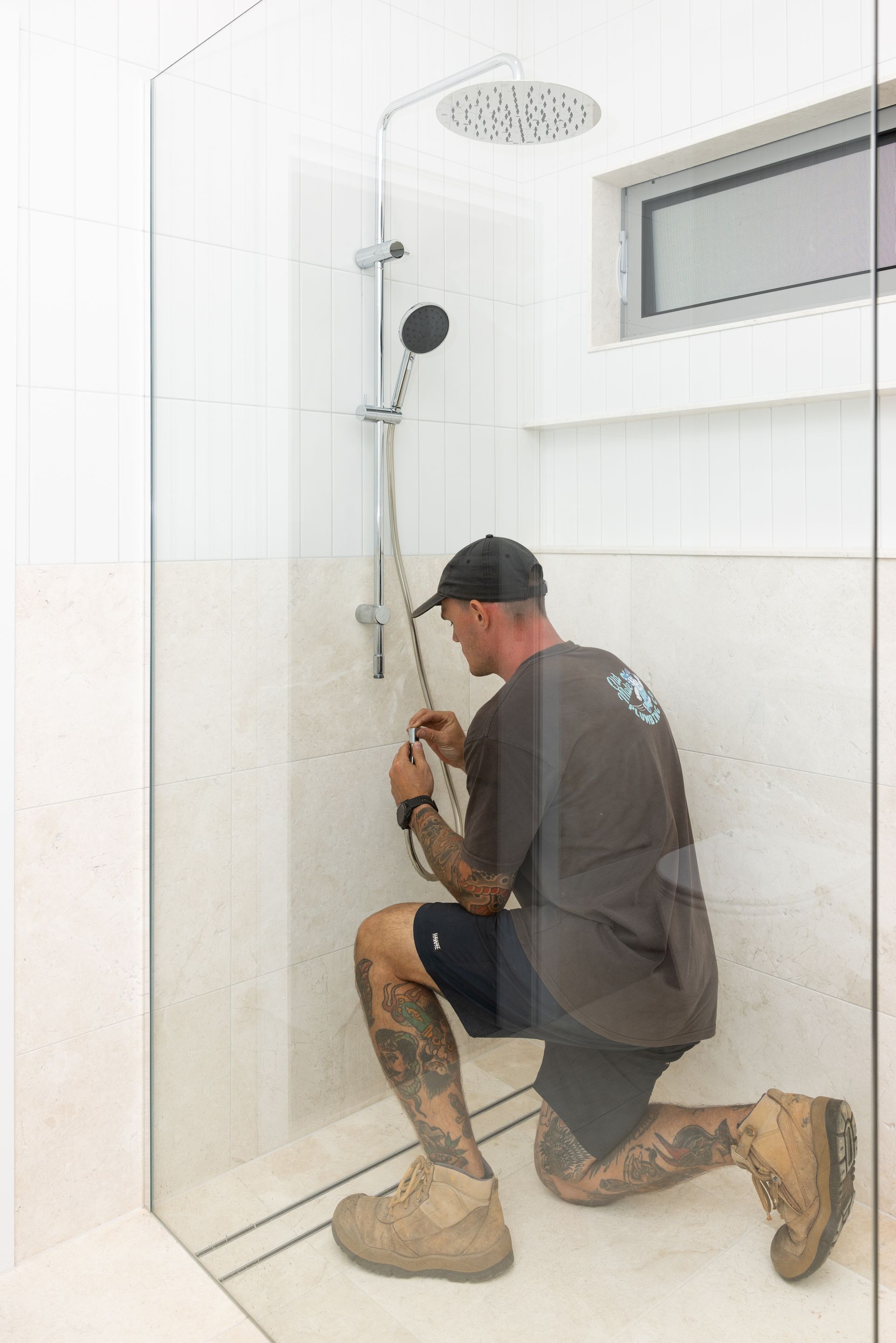 A Man In Black Shirt In SIde Of Shower Fixing The Hose — Old Mate Plumbing Co in Hollywell, QLD