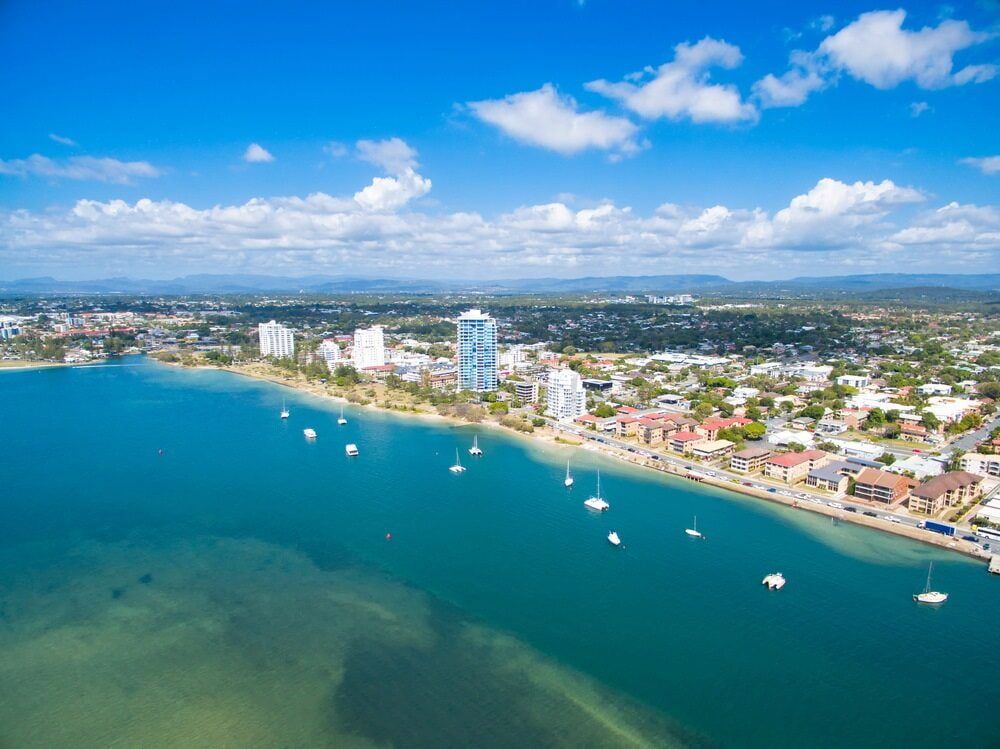 An Aerial View Of A City Next To A Body Of Water — Old Mate Plumbing Co in Labrador, QLD