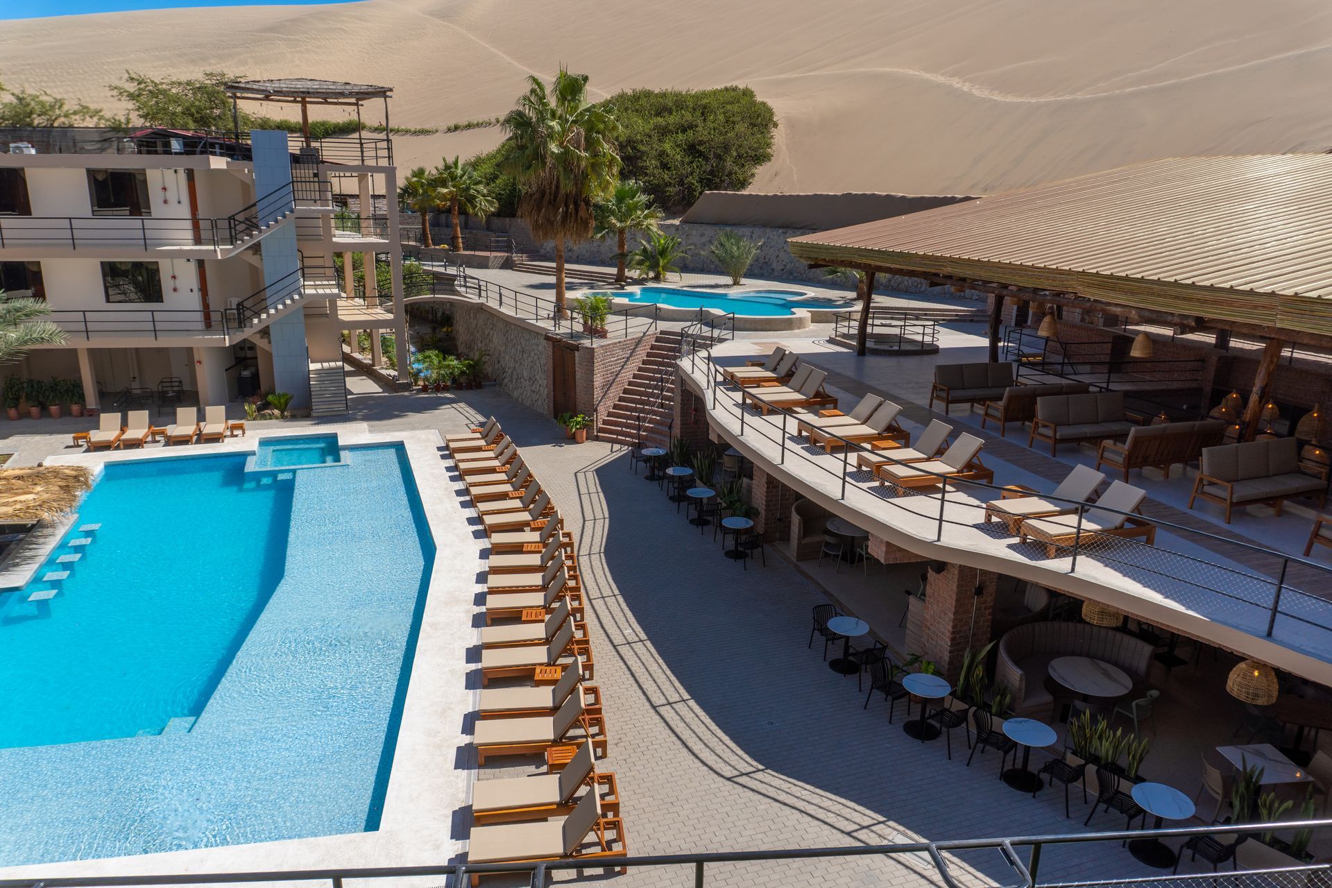 An aerial view of a hotel with a large swimming pool