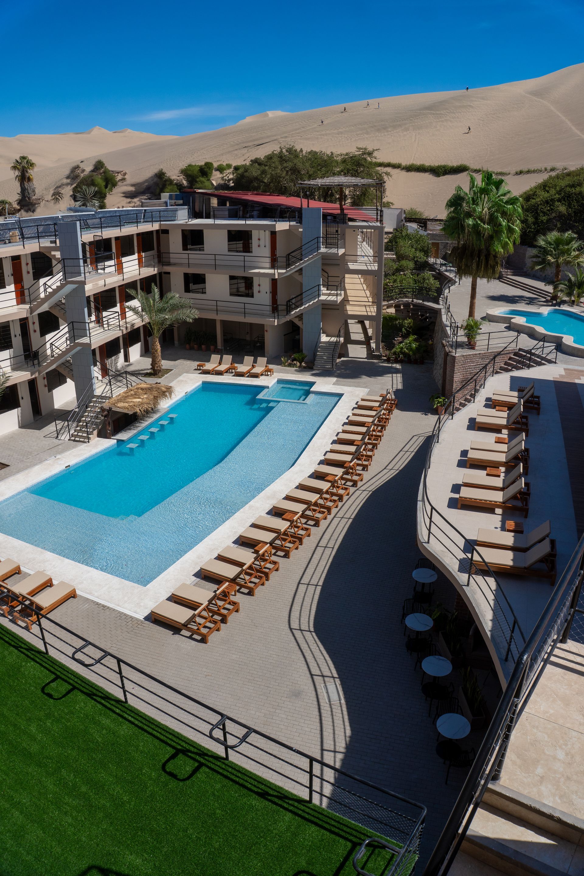 An aerial view of a hotel with a large swimming pool