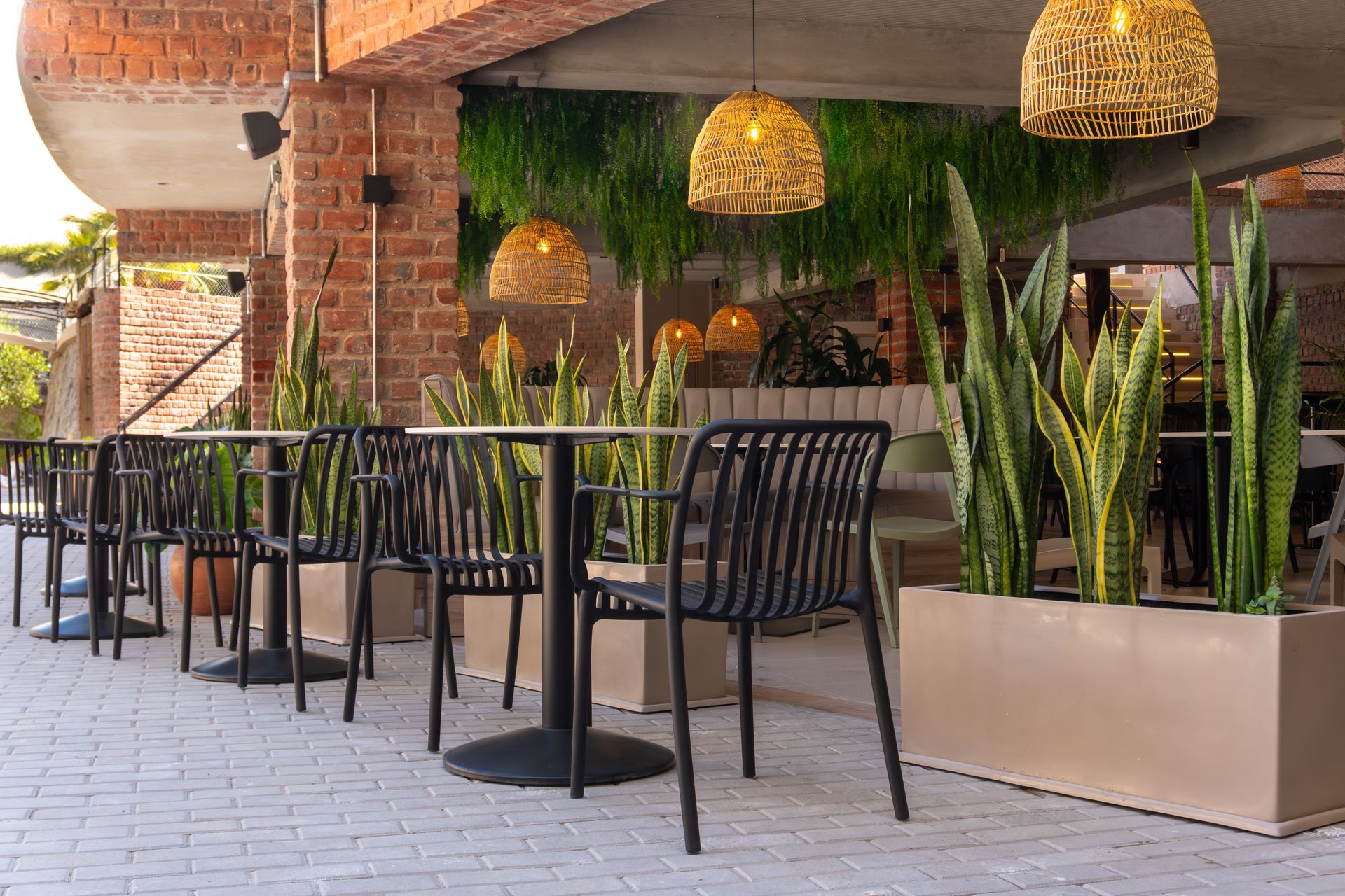 A row of tables and chairs outside of a restaurant.