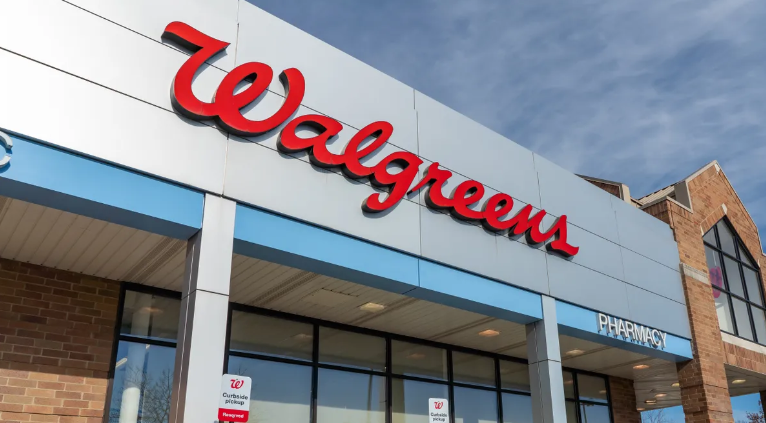 The front of a walgreens store with a red and white sign.