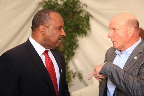 Two men in suits and ties are talking to each other.