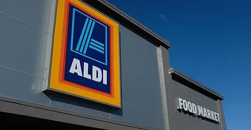 The front of an aldi store with a blue sky in the background.