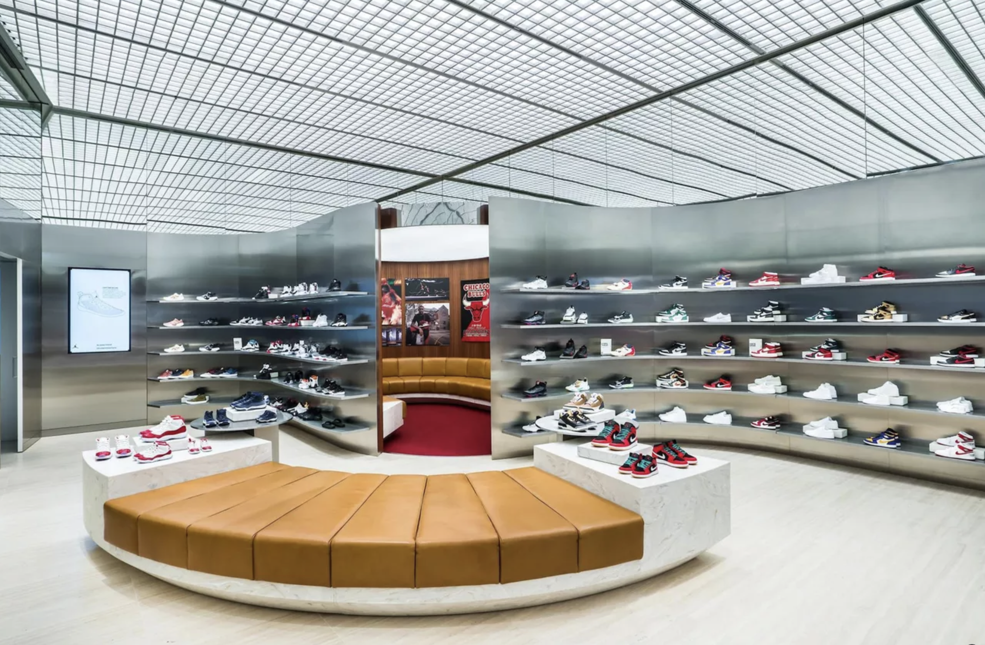 A shoe store with a round bench in the middle of the room.