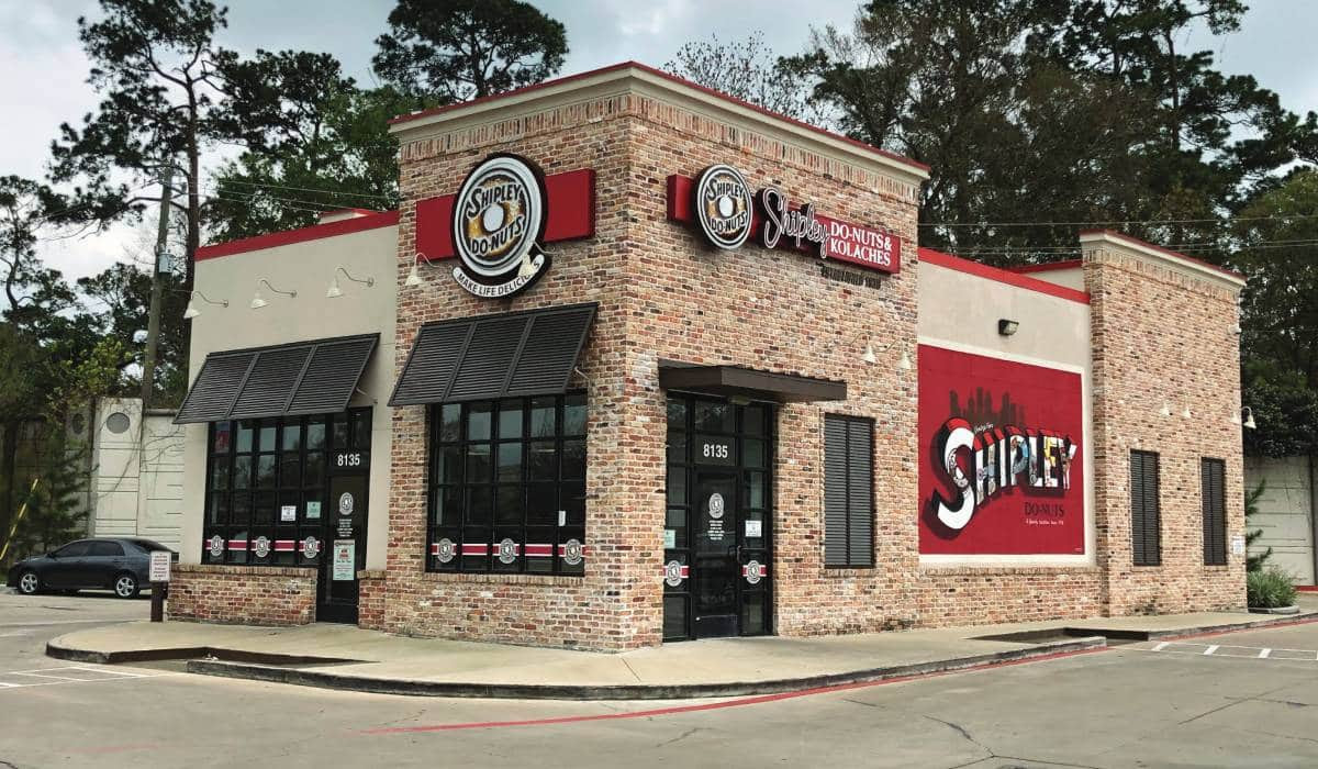 A brick building with a red and white sign that says snipple on it.