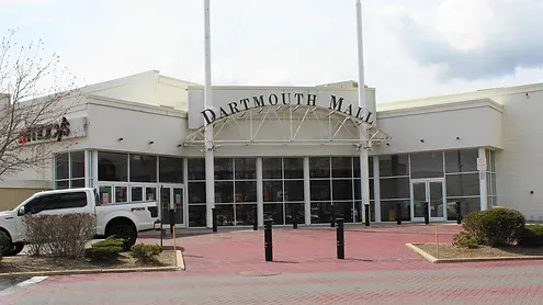 A white truck is parked in front of the dartmouth mall.