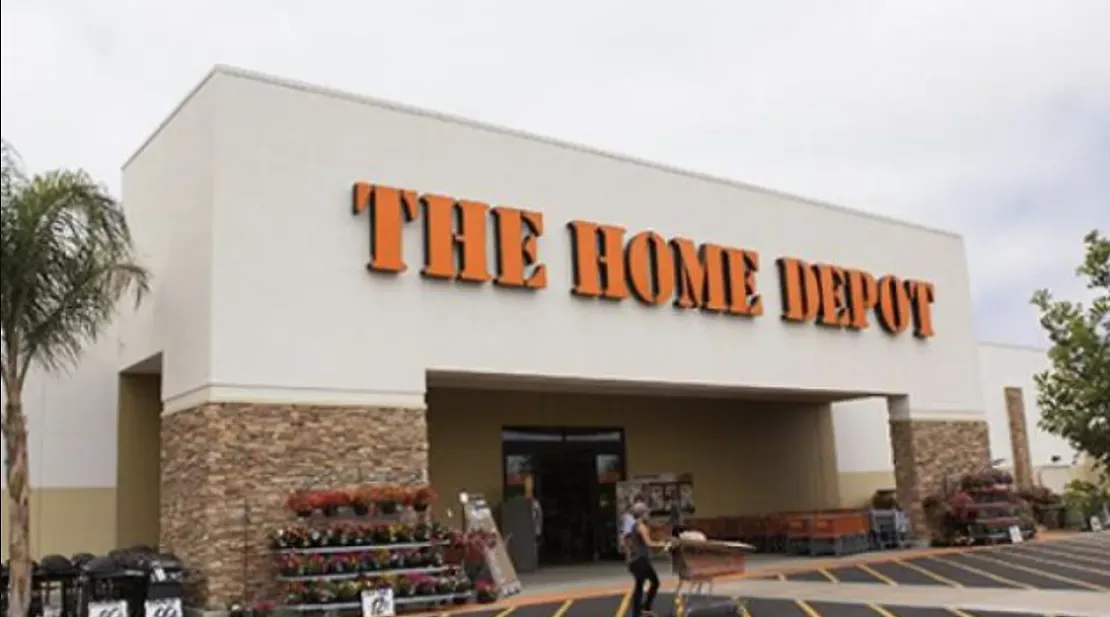 A man is standing in front of a home depot store