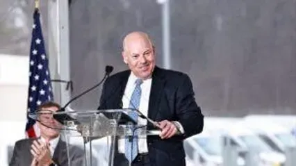 A man in a suit and tie is standing at a podium giving a speech.