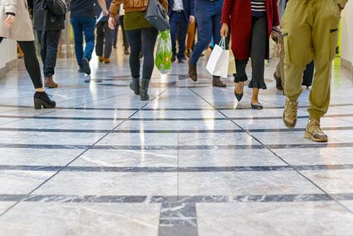 A group of people are walking down a tiled floor.