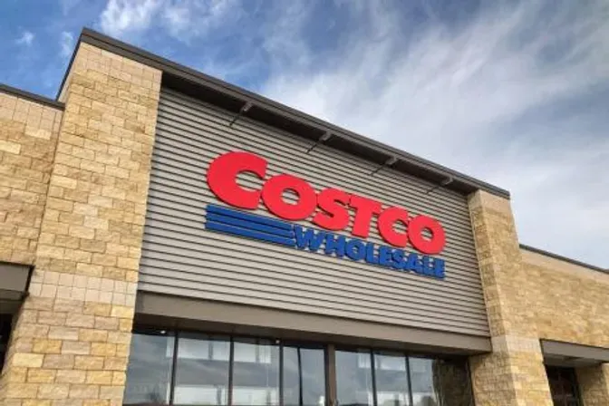 The front of a costco wholesale store with a blue sky in the background.