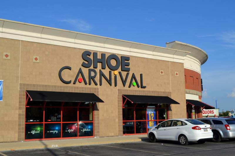 A shoe carnival store with cars parked in front of it