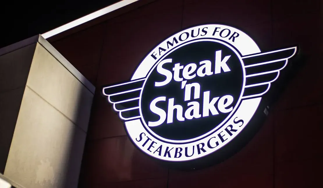 A steak n shake sign is lit up at night
