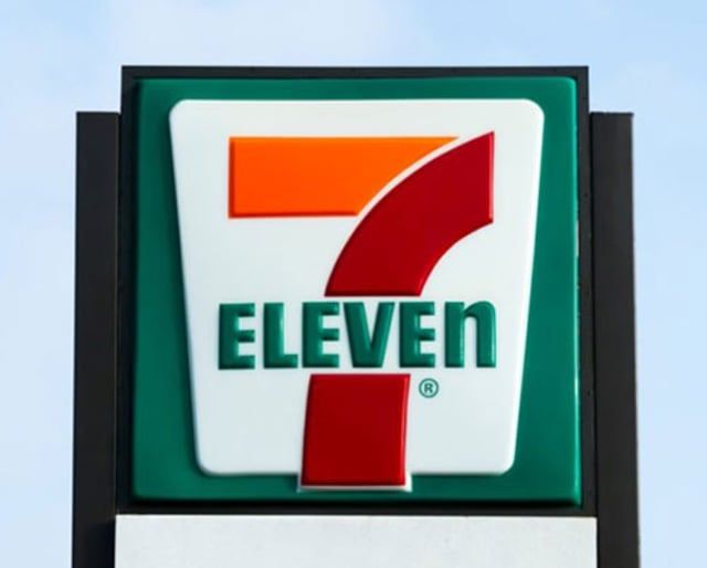 A 7 eleven sign against a blue sky