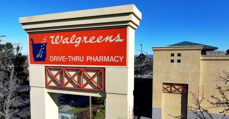 A walgreens drive thru pharmacy sign in front of a building