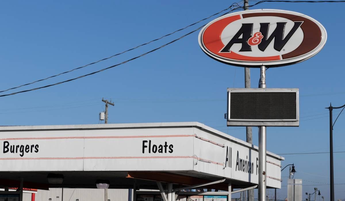 A sign for aw burgers and floats is above a building