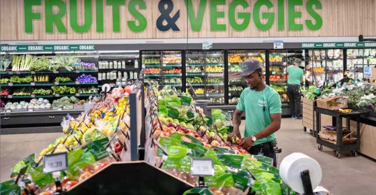 A man is shopping for fruits and vegetables in a grocery store.