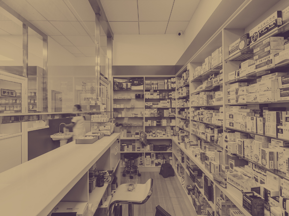 A pharmacy with a lot of shelves and a counter.