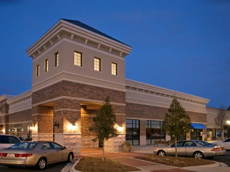 A building with cars parked in front of it at night