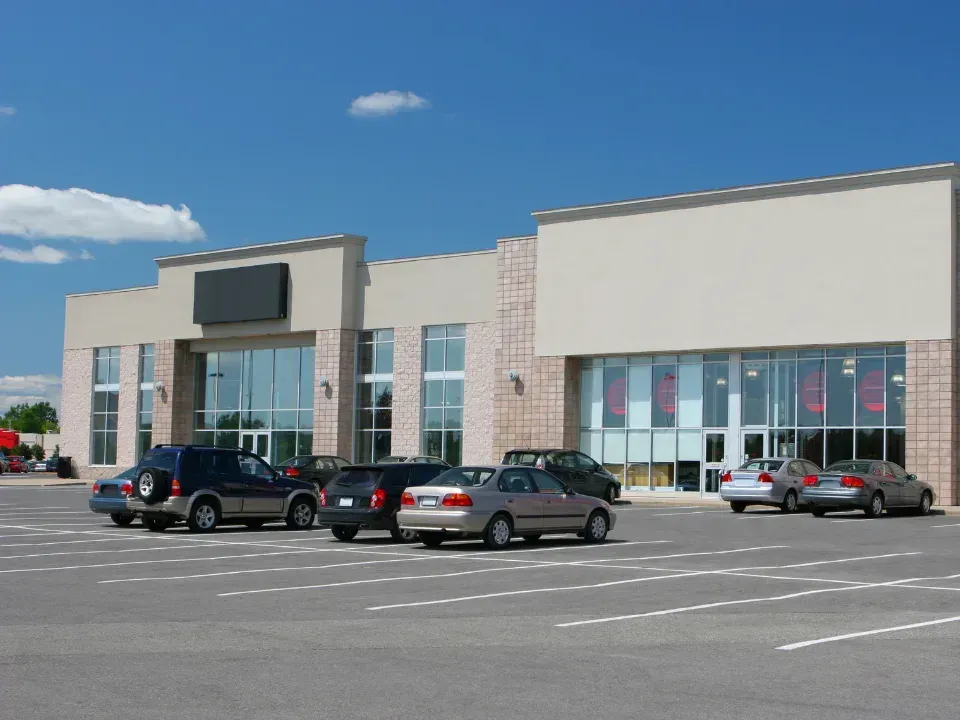 A lot of cars are parked in front of a building
