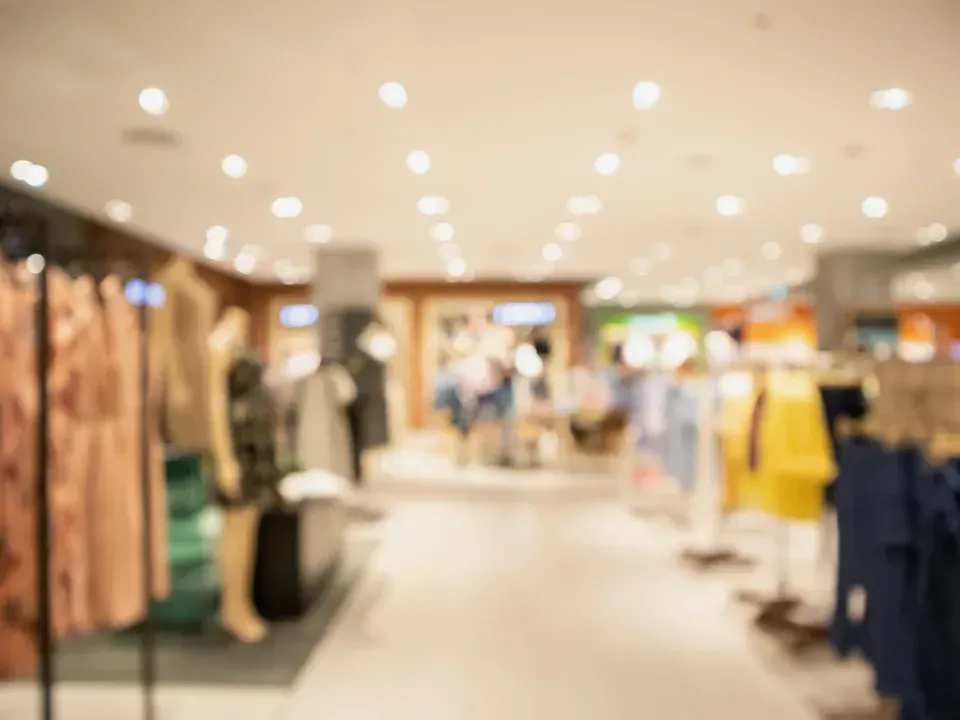 A blurry picture of a clothing store with clothes on display.